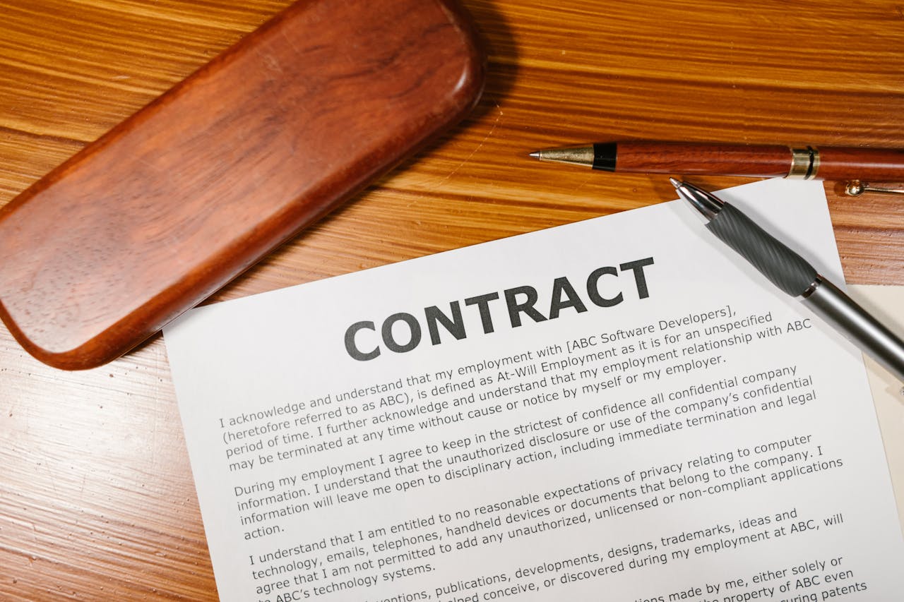 About A close-up view of a contract and pen on a wooden desk, ideal for business themes.